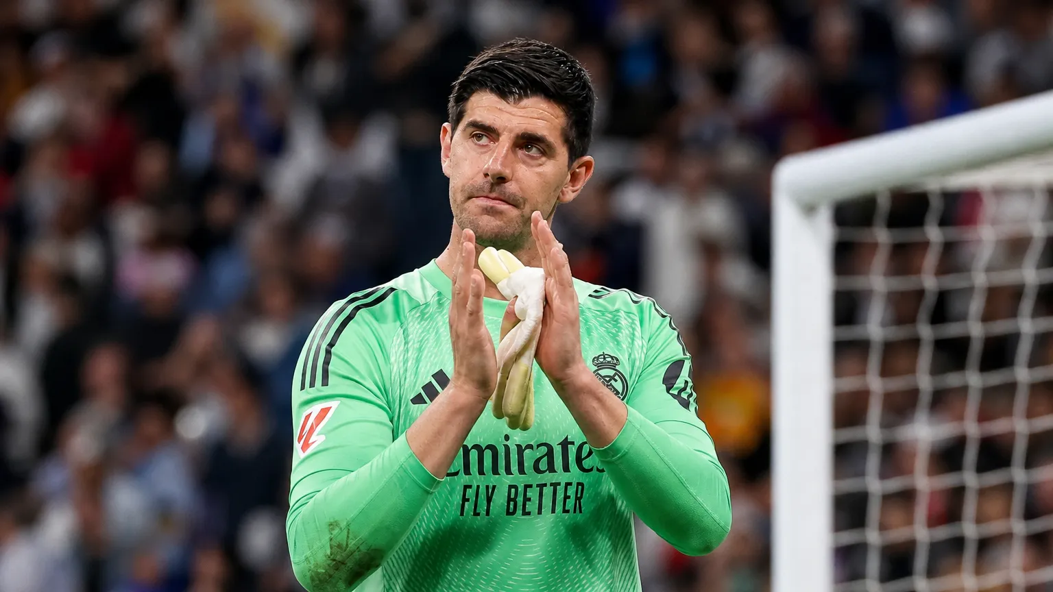 Thibaut Courtois applaudisseert in het doelgebied in zijn Real Madrid-tenue.