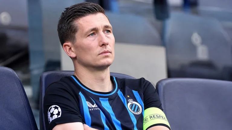 Hans Vanaken in een blauw-zwart Club Brugge-shirt op de tribune van een stadion.