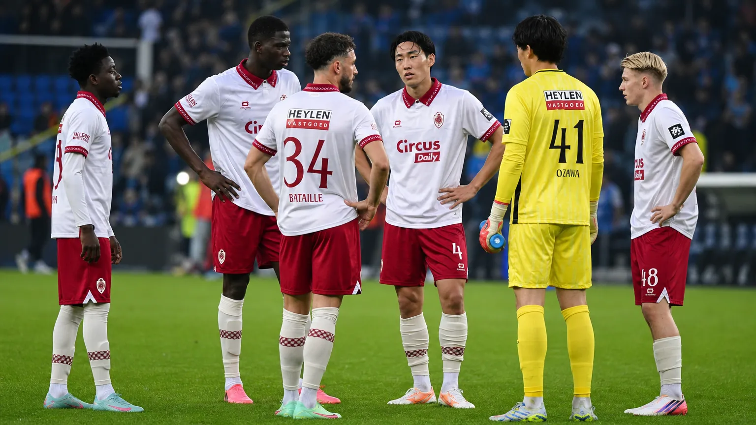 Een groep Antwerp-spelers overlegt na afloop op het veld.