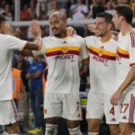 Een groep AS Roma-spelers viert samen langs het veld tijdens een wedstrijd.