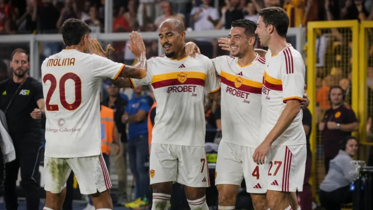 Een groep AS Roma-spelers viert samen langs het veld tijdens een wedstrijd.