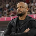 Een coach uit de technische staf van Bayern München langs de zijlijn van een voetbalstadion.