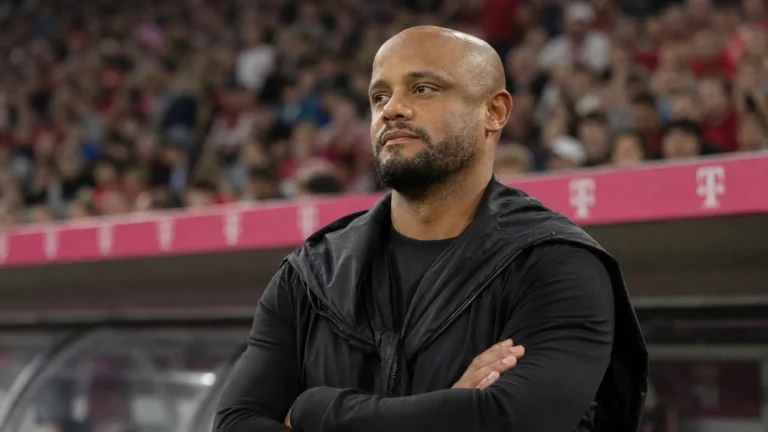 Een coach uit de technische staf van Bayern München langs de zijlijn van een voetbalstadion.