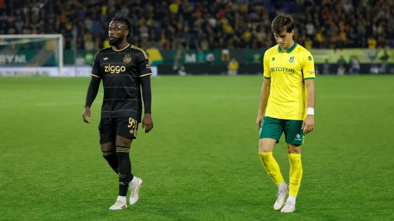 Twee voetballers wandelen na afloop over het veld in het stadion van Fortuna Sittard.