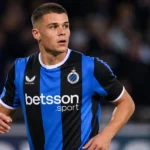 Nicolo Tresoldi van Club Brugge kijkt geconcentreerd op het veld tijdens een avondwedstrijd.