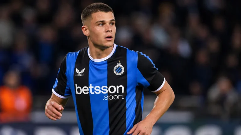 Nicolo Tresoldi van Club Brugge kijkt geconcentreerd op het veld tijdens een avondwedstrijd.