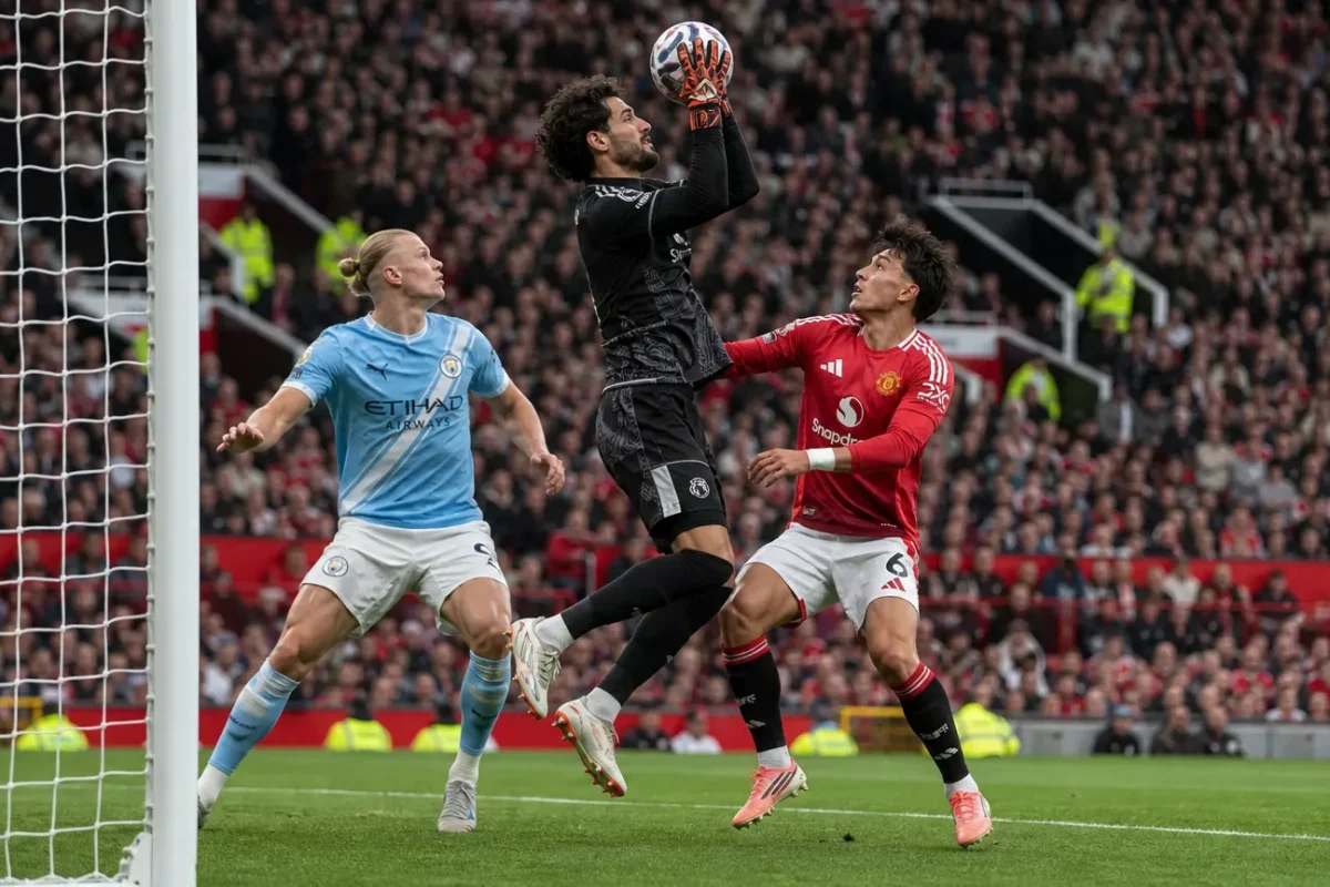 Een doelman en drie spelers in actie voor het doel tijdens een Manchester-derby.
