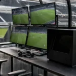 Een lege VAR-werkplek met wedstrijdmonitoren in een stadion van de Jupiler Pro League.