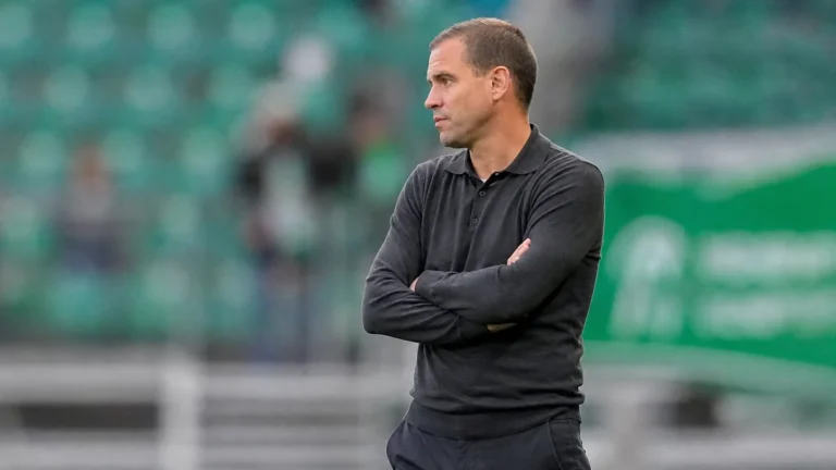 Michiel Jonckheere in donker bovenstuk langs de zijlijn van een voetbalveld.