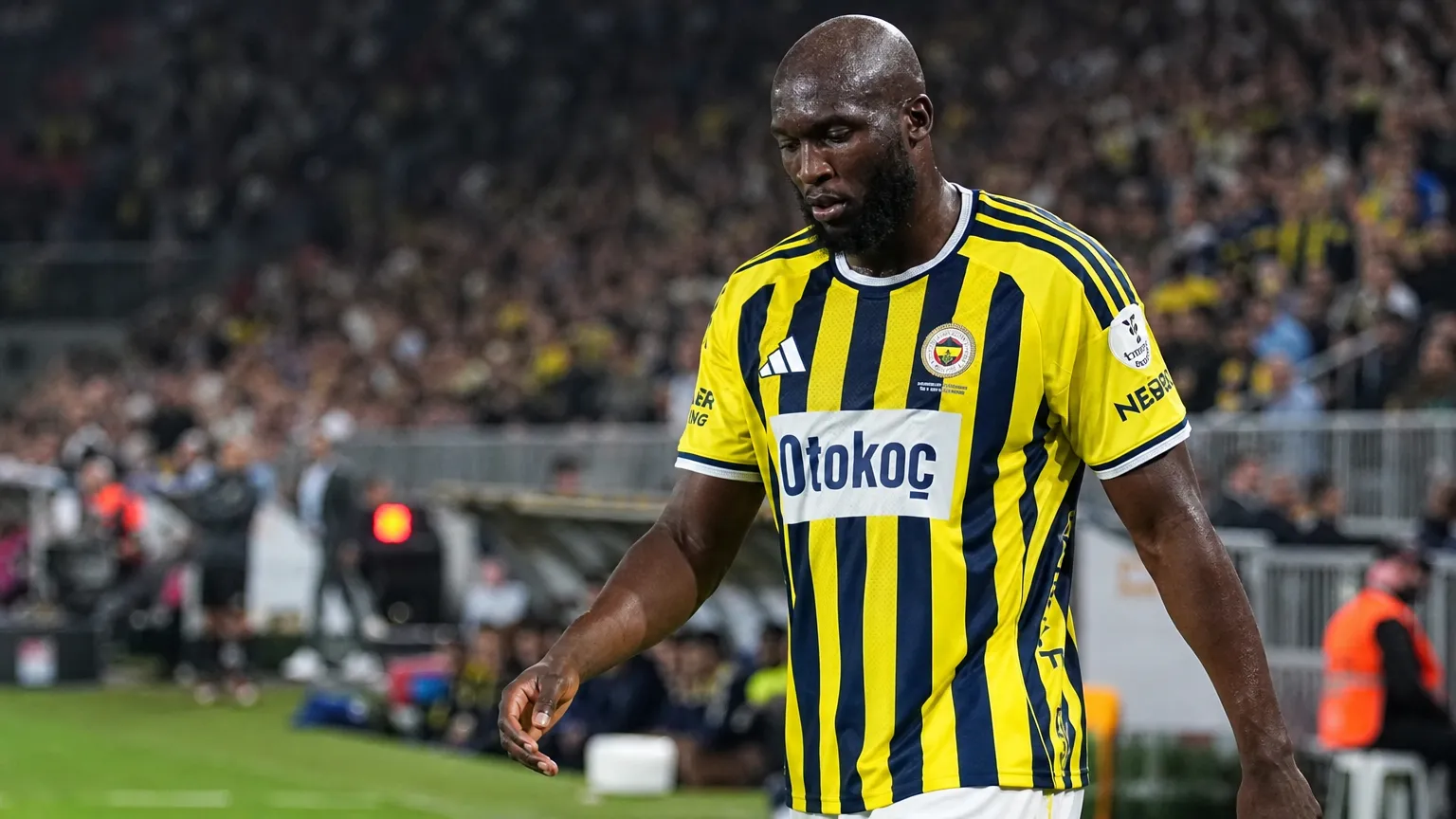 Romelu Lukaku wandelt in het geel-blauwe shirt van Fenerbahçe richting de zijlijn.