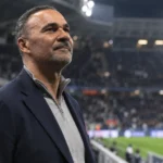 Ruud Gullit kijkt aandachtig omhoog in een stadion.