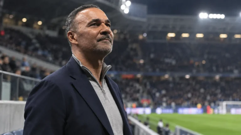 Ruud Gullit kijkt aandachtig omhoog in een stadion.