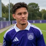 Enzo Sternal in een paars voetbalshirt aan de rand van een groen veld.