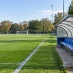 Leeg trainingsveld van de U23 van Union met het clubembleem op de dug-out.