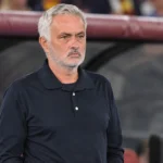 José Mourinho in een donker poloshirt naast de technische zone van een voetbalstadion.