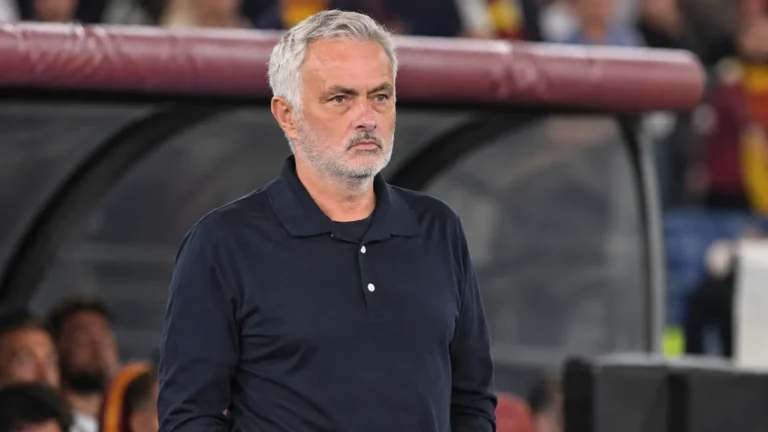 José Mourinho in een donker poloshirt naast de technische zone van een voetbalstadion.