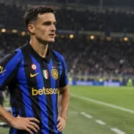 Een Inter-middenvelder in blauw-zwart tenue staat na de wedstrijd op het veld.