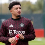 Jadon Sancho drinkt water tijdens een warming-up in Manchester United-kleding.