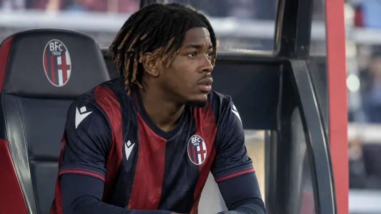 Samuel Mbangula zit geconcentreerd op de bank in een Bologna-dug-out.