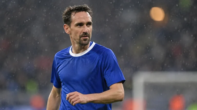 Sven Kums in blauw tenue op een regenachtig Europees voetbalveld.