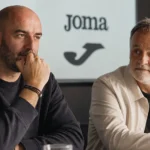 Twee niet-spelende clubmedewerkers in een rustige mediaruimte.