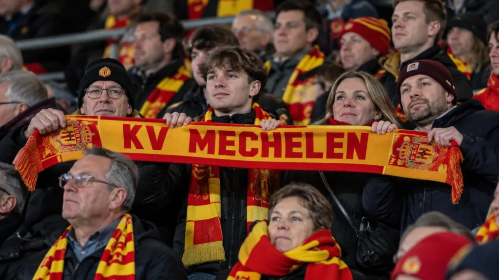 Een groep KV Mechelen-supporters met sjaals in de tribune.