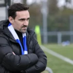 Sven Kums kijkt langs de zijlijn naar een jeugdwedstrijd van KAA Gent.