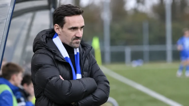 Sven Kums kijkt langs de zijlijn naar een jeugdwedstrijd van KAA Gent.