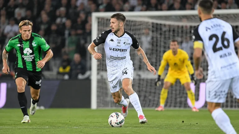 Ryan Merlen van STVV in actie in een wit-zwart tenue op het voetbalveld.