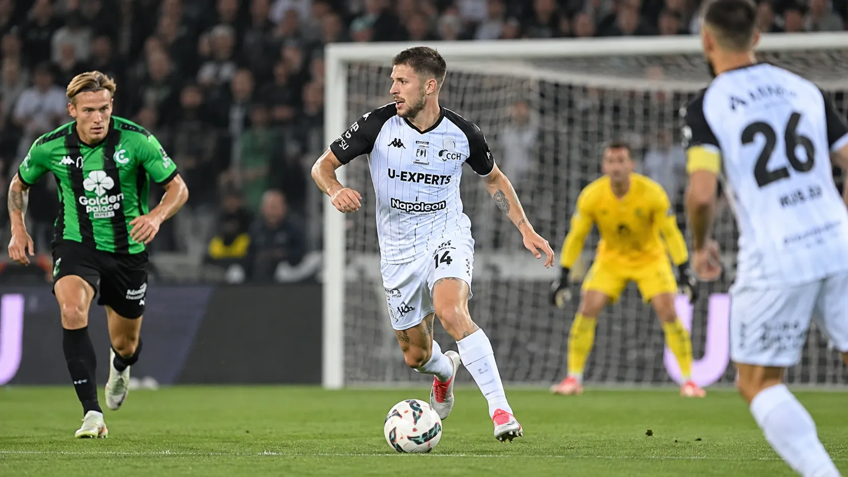 Ryan Merlen van STVV in actie in een wit-zwart tenue op het voetbalveld.