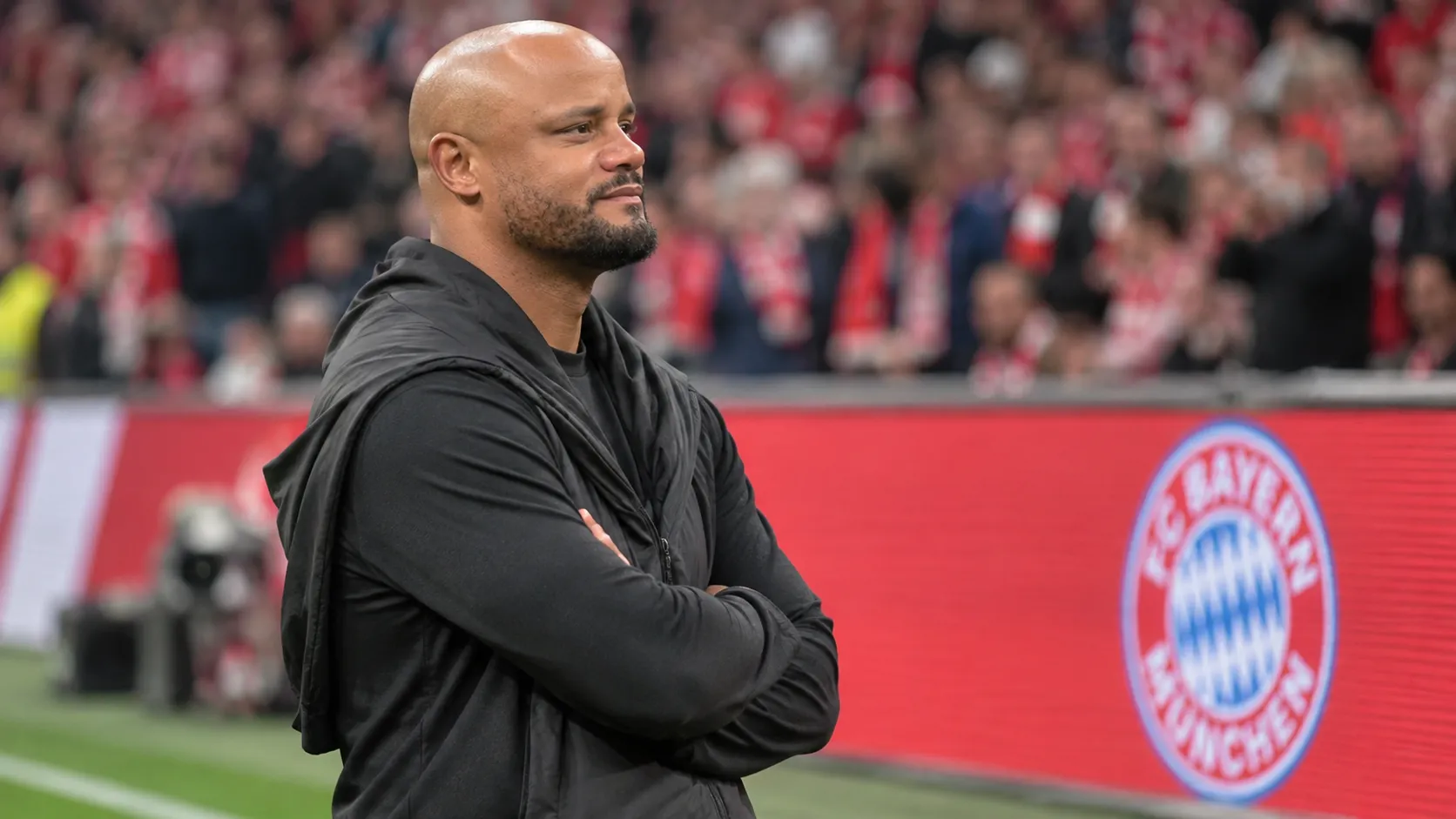 Een niet-spelende clubvertegenwoordiger in zwarte kleding langs de zijlijn, met een Bayern München-bord op de achtergrond.