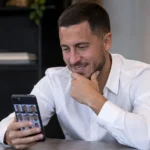 Eden Hazard bekijkt een smartphone tijdens een quiz over voormalige ploegmaats.