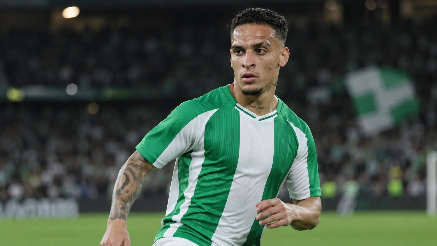 Antony in een groen-wit wedstrijdshirt tijdens een avondwedstrijd op het veld.