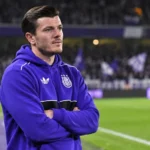 Giulian Biancone in een paarse Anderlecht-hoodie aan de rand van het stadion.