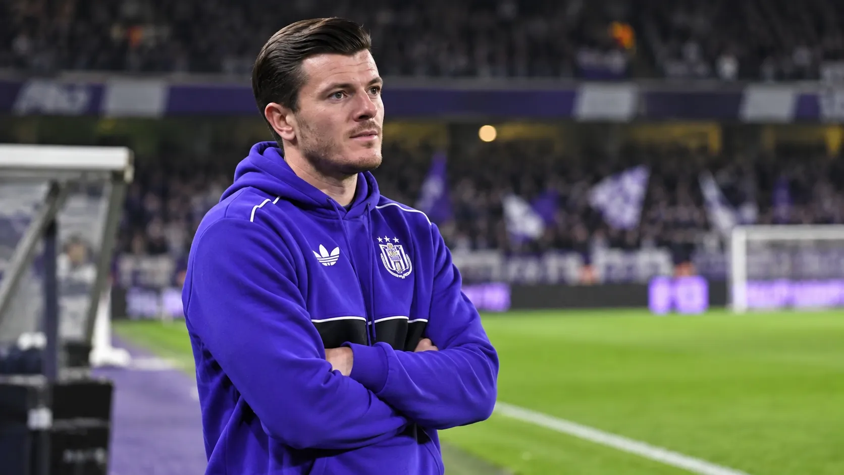 Giulian Biancone in een paarse Anderlecht-hoodie aan de rand van het stadion.
