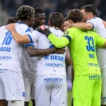 Spelers van KAA Gent vormen na een wedstrijd een hechte kring op het veld.