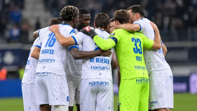 Spelers van KAA Gent vormen na een wedstrijd een hechte kring op het veld.