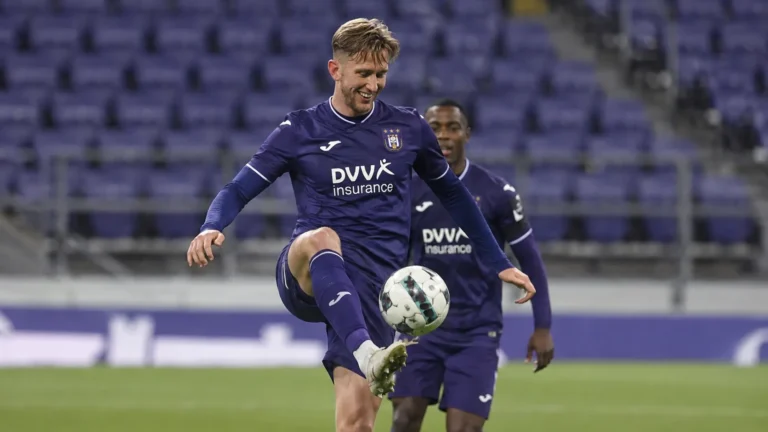 Een Anderlecht-speler in paars wedstrijdtenue tijdens een wedstrijdmoment op het veld.