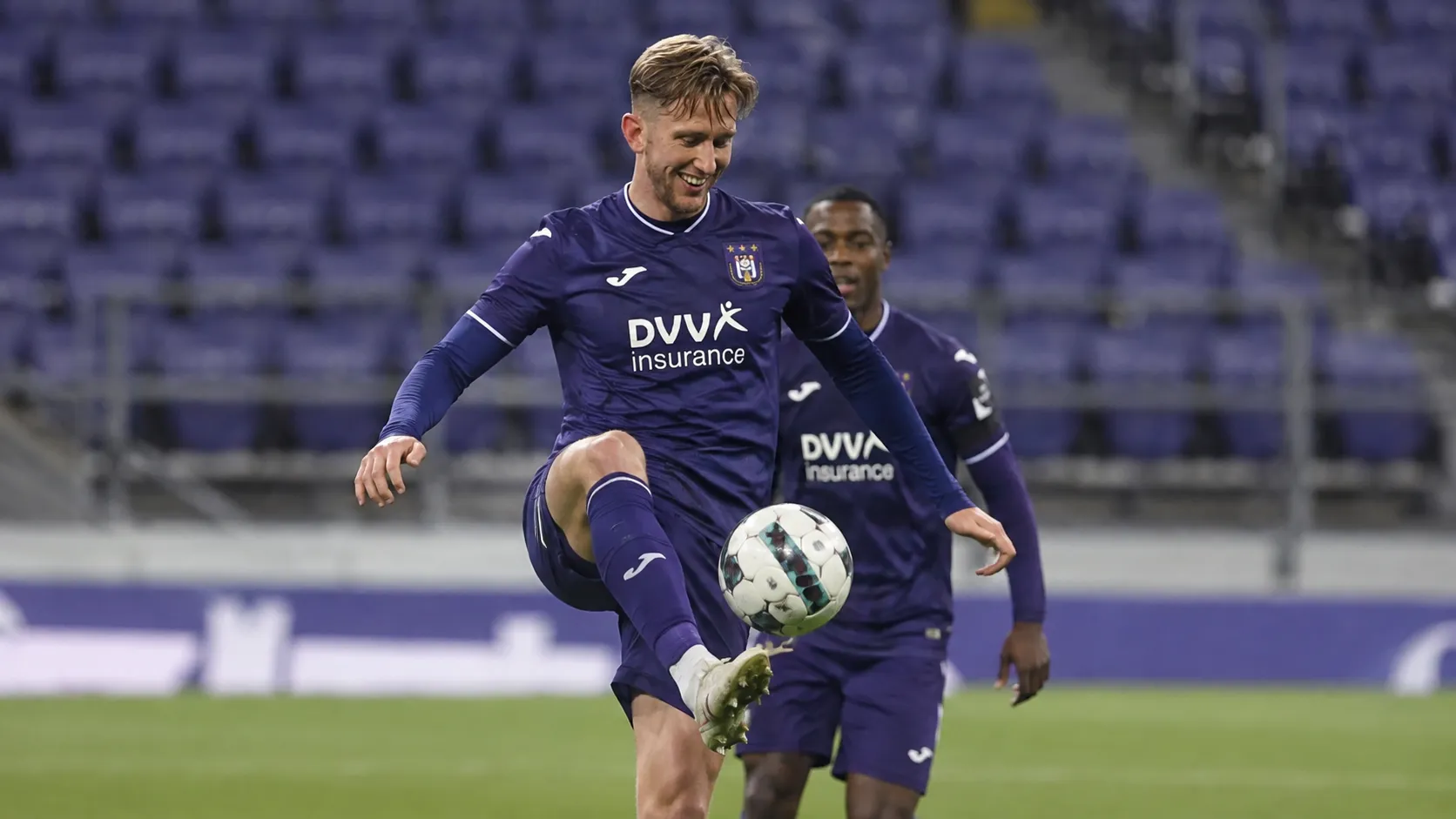 Een Anderlecht-speler in paars wedstrijdtenue tijdens een wedstrijdmoment op het veld.