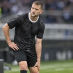Siebe Van der Heyden in zwart wedstrijdshirt tijdens een korte onderbreking op het veld.