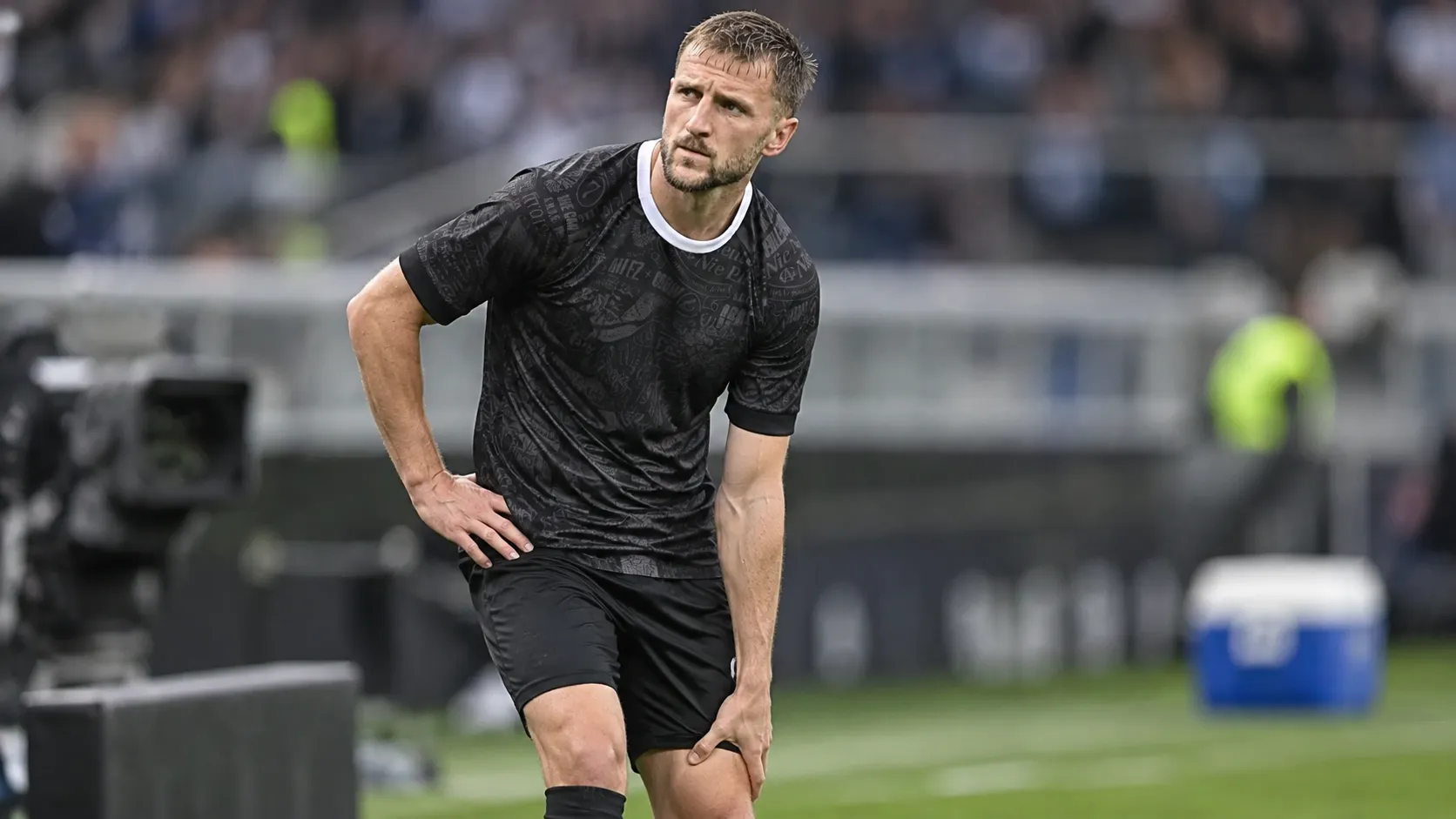 Siebe Van der Heyden in zwart wedstrijdshirt tijdens een korte onderbreking op het veld.