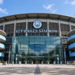 De voorgevel van het Etihad Stadium met de Manchester City-crest aan de ingang.