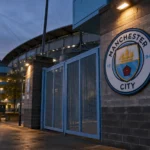 Lege toegangspoort van het stadion van Manchester City met een clubembleem op de gevel.