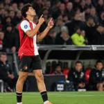 Nacho Ferri in Feyenoord-tenue op het veld, met zijn handen omhoog.