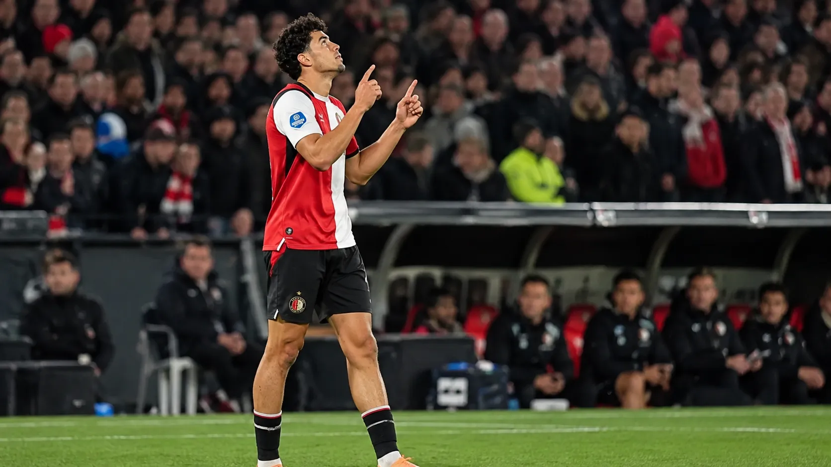 Nacho Ferri in Feyenoord-tenue op het veld, met zijn handen omhoog.