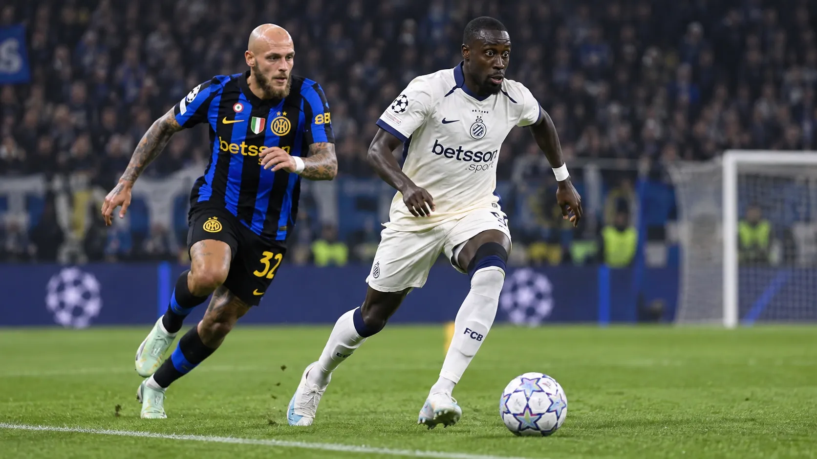 Een Club Brugge-aanvaller dribbelt met de bal terwijl een Inter-verdediger hem achtervolgt.