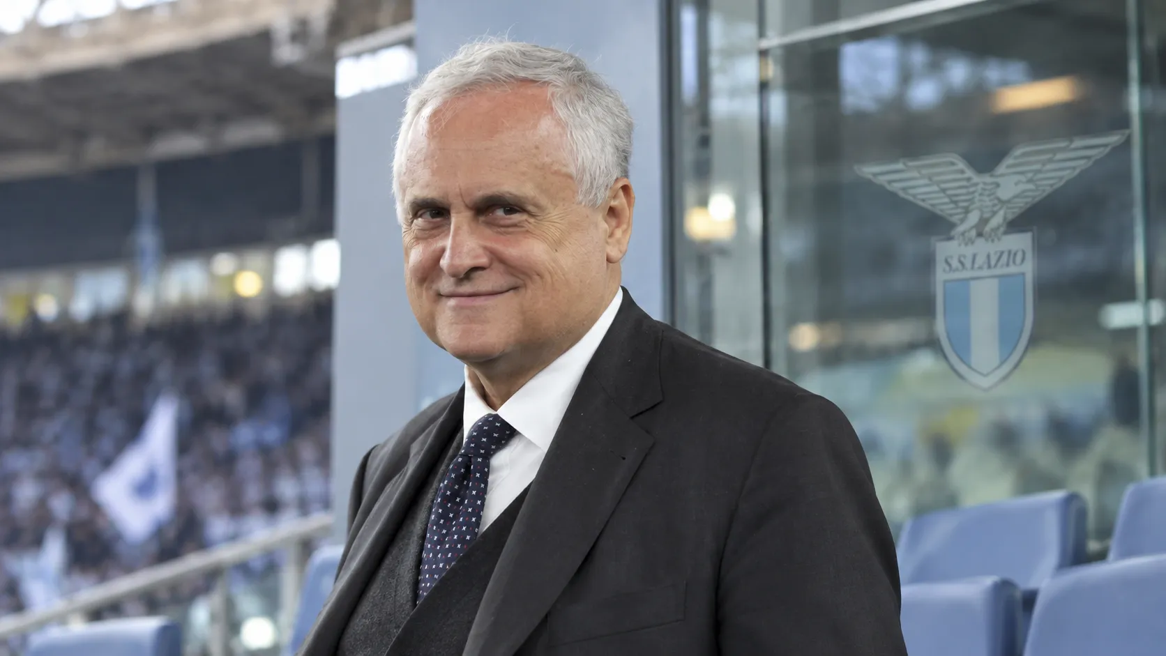 Claudio Lotito in donker pak in een Lazio-stadionomgeving.