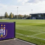 Leeg trainingsveld van RSC Anderlecht met een paars trainingsbord langs de zijlijn.