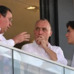 Niet-spelende clubvertegenwoordigers overleggen in een stadionbox.