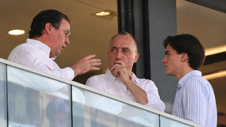 Niet-spelende clubvertegenwoordigers overleggen in een stadionbox.